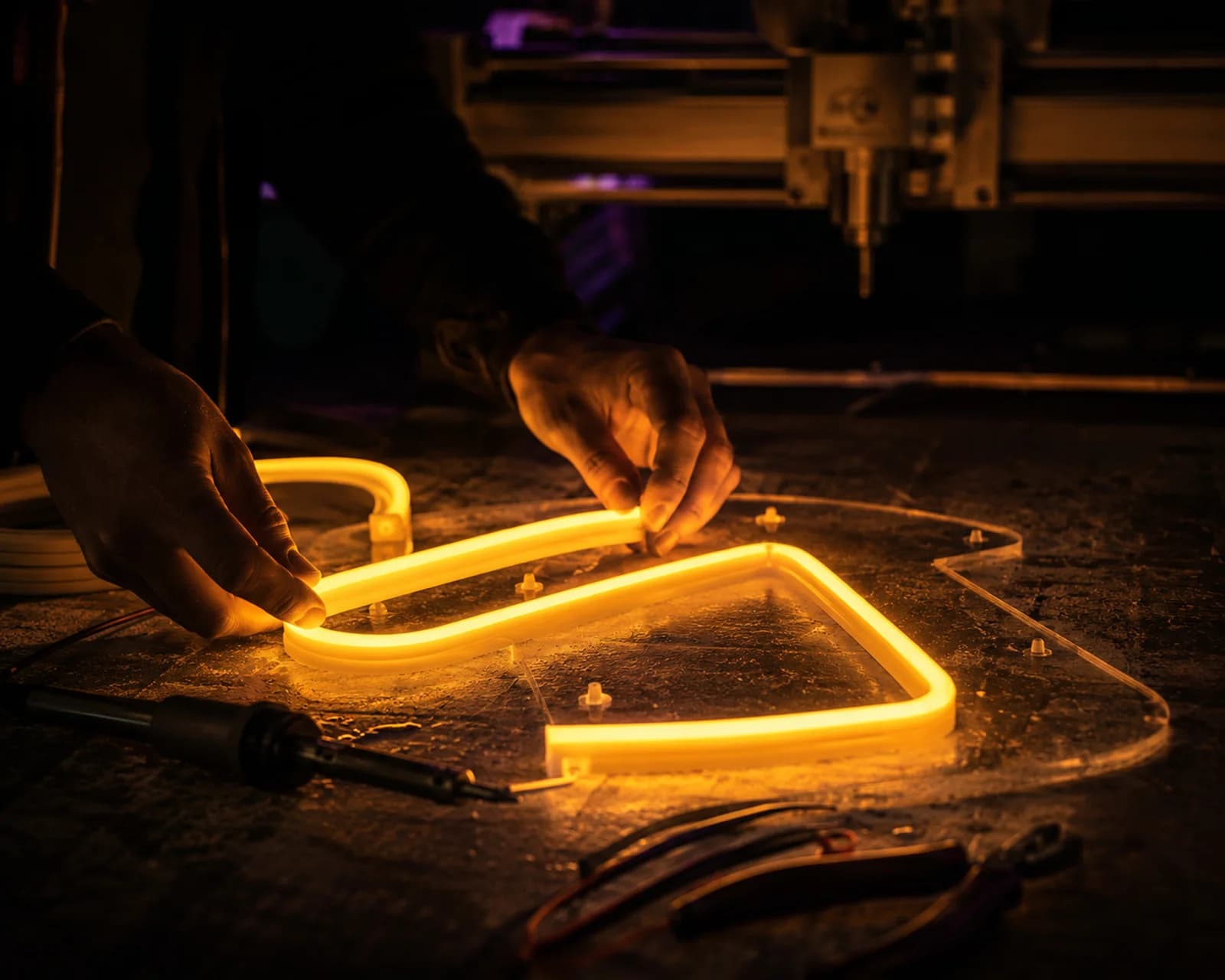 Met de hand buigen van warm gloeiende LED-neonflex op de werkbank van Living Lumen.