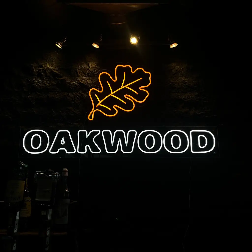 Maatwerk neon logo met blad en tekst gemonteerd op donkere wand in interieur