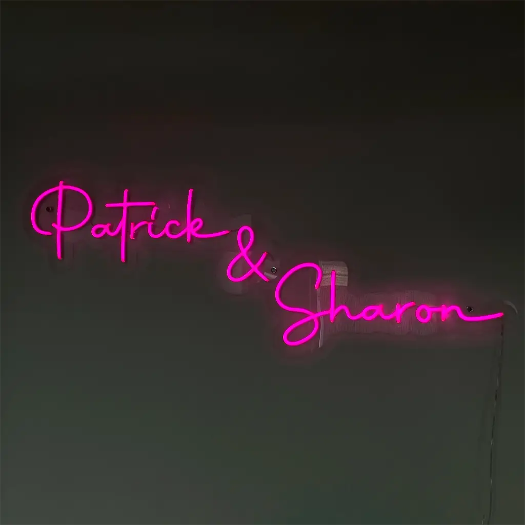Roze neon naam op maat met de namen Patrick & Sharon in sierlijke letters, geschikt voor interieurdecoratie en gepersonaliseerde verlichting.