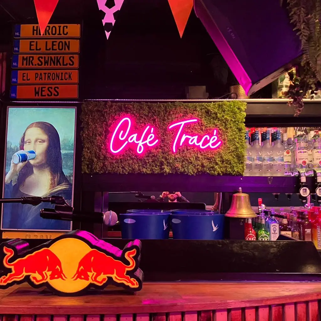 Roze neon tekst gemonteerd op groene wand in horeca interieur