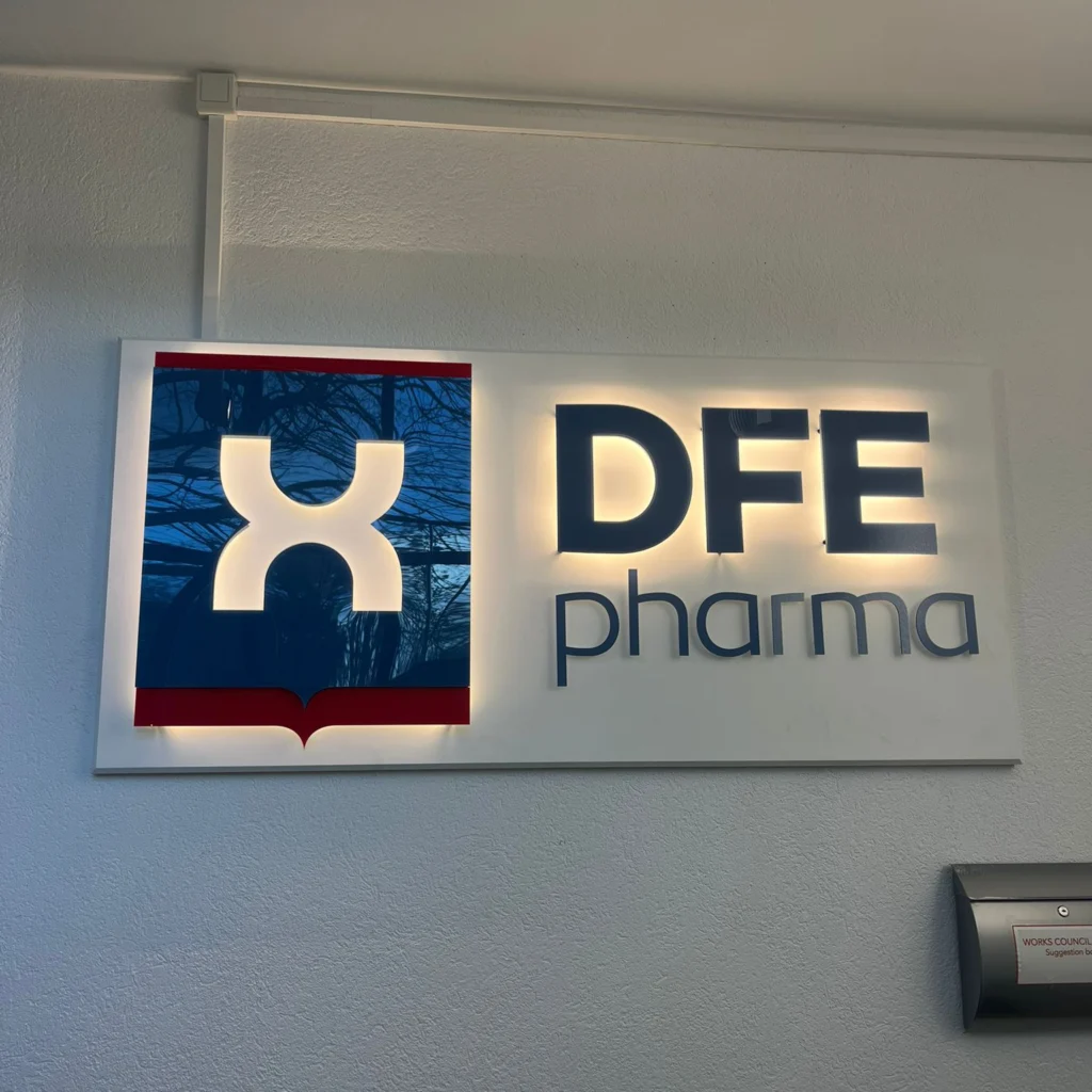 LED verlicht logo DFE Pharma op kantoorwand met indirecte verlichting en strakke afwerking