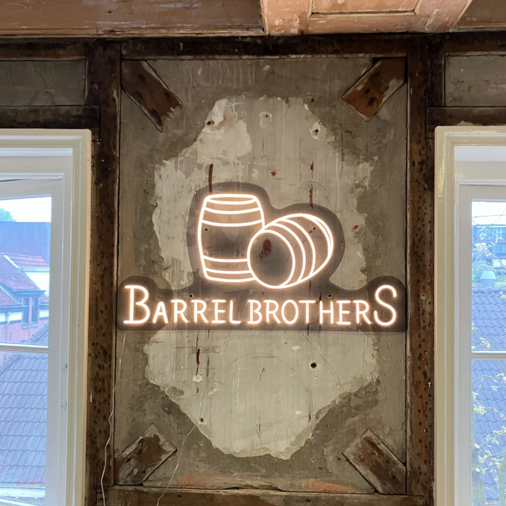 LED neon logo Barrel Brothers met houten vaten in horecazaak met industriële uitstraling