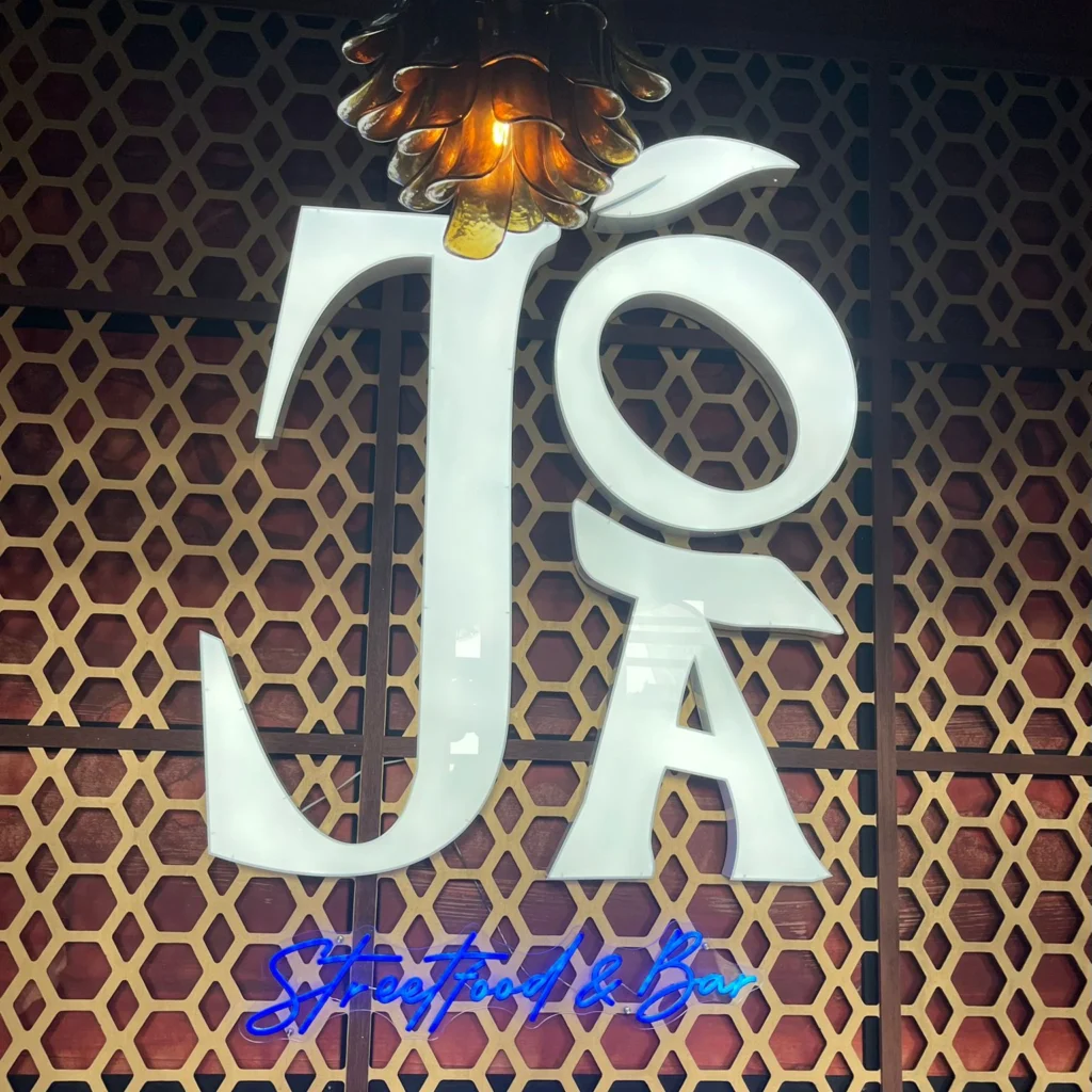 Neon logo en verlichte signage in streetfood bar restaurant interieur met blauw neon accent