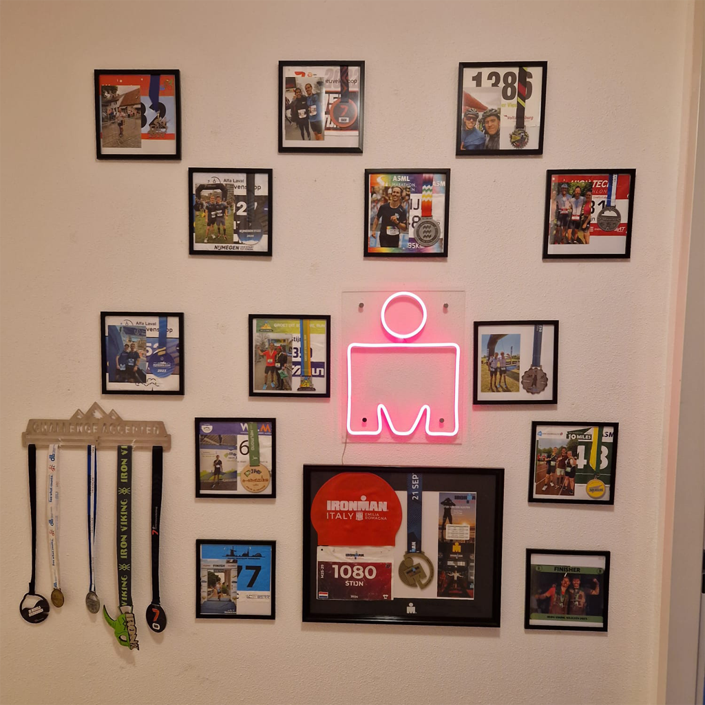 Roze LED neon sign boven sportmedailles en Ironman wand in interieur